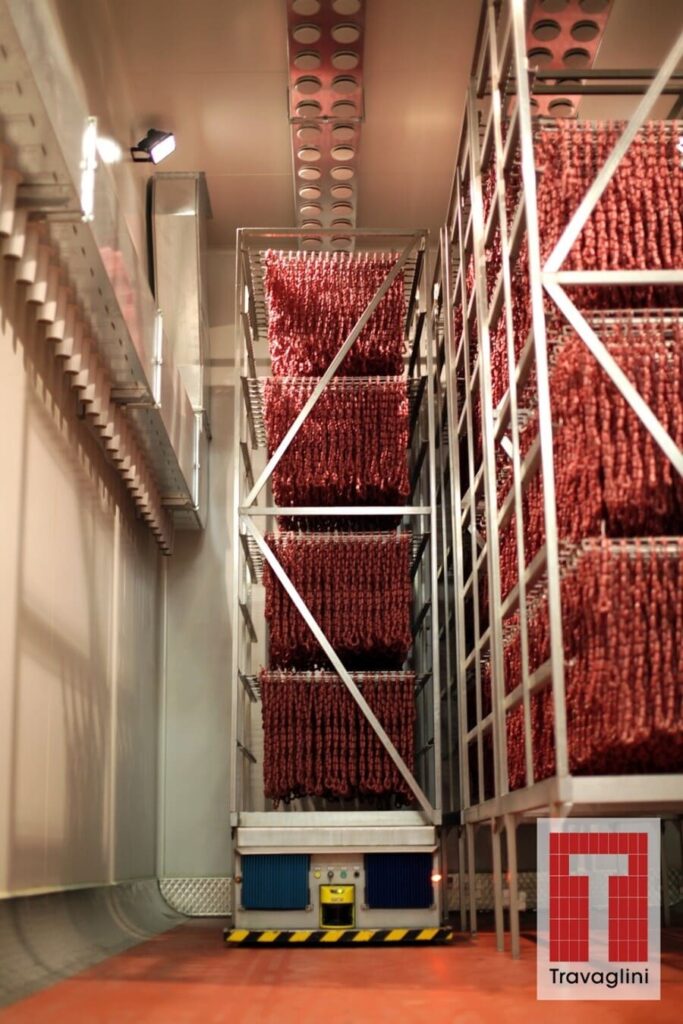 Travaglini equipment moving trolleys of cured meat in a smokehouse