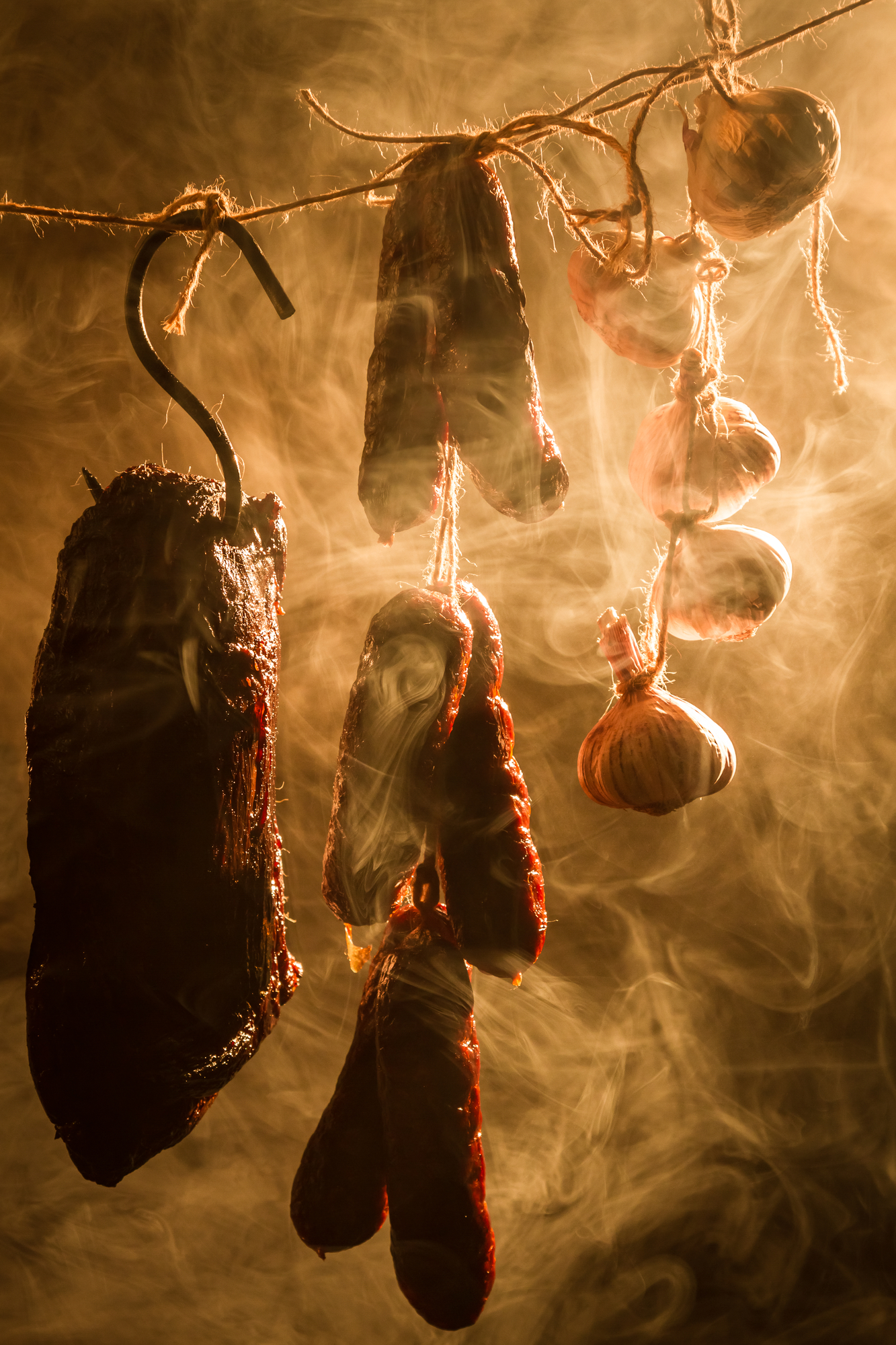 a selection of smoked products hanging in a traditional smokehouse